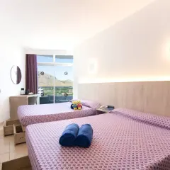 Habitación doble con vistas en Club Mac Alcudia. Dos camas listas para descansar tras un día de sol.