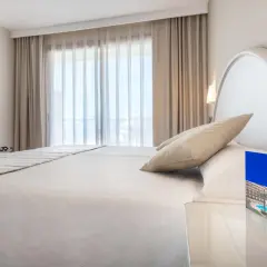 Habitación luminosa con cama doble, TV y folleto del Vik Gran Hotel Costa del Sol.