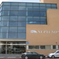 Fachada moderna del hotel Neptuno Roquetas de Mar, con amplios ventanales y detalles en ladrillo.
