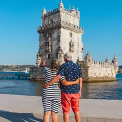 Pareja disfrutando de sus vacaciones en Portugal, admirando la Torre de Belém en Lisboa.
