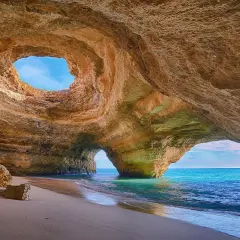 Cueva marina con arco natural y playa de arena. Un lugar perfecto donde viajar en noviembre para disfrutar del sol y el mar.