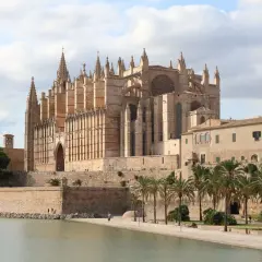 La Catedral de Mallorca, un impresionante edificio gótico, se alza majestuosa junto al mar, evocando la grandeza de Barcelona.