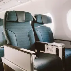 Asientos de business class en un avión, con espacio amplio y detalles de lujo.