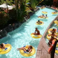 Un día perfecto de diversión en Tenerife con niños, flotando en un río artificial rodeado de vegetación exuberante.