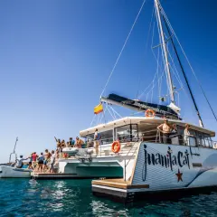 Catamarán "Juanita Cat" listo para el ferry Lanzarote La Graciosa. Turistas disfrutan del sol y el mar azul.