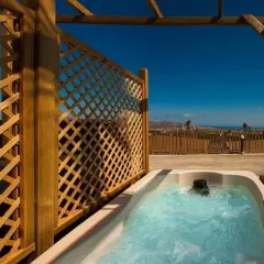 Jacuzzi burbujeante en un balcón con vistas al mar, parte de la experiencia mágica en Natura Resort.