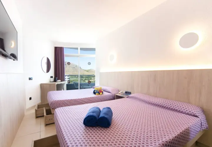 Habitación doble con vistas en Club Mac Alcudia. Dos camas listas para descansar tras un día de sol.