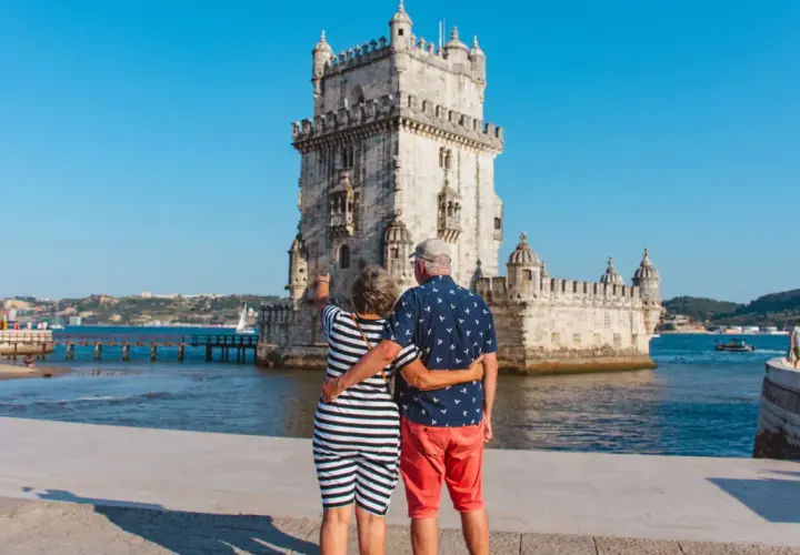 Pareja disfrutando de sus vacaciones en Portugal, admirando la Torre de Belém en Lisboa.