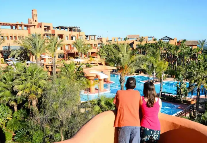 Pareja admira las piscinas y palmeras del Royal Hideaway Sancti Petri.