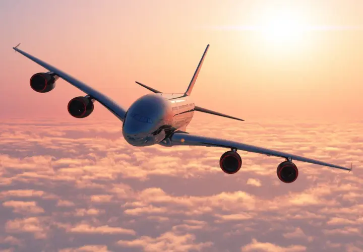 Avión sobrevolando nubes al amanecer, ideal para tus viajes organizados desde Barcelona.
