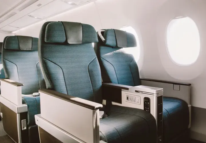 Asientos de business class en un avión, con espacio amplio y detalles de lujo.