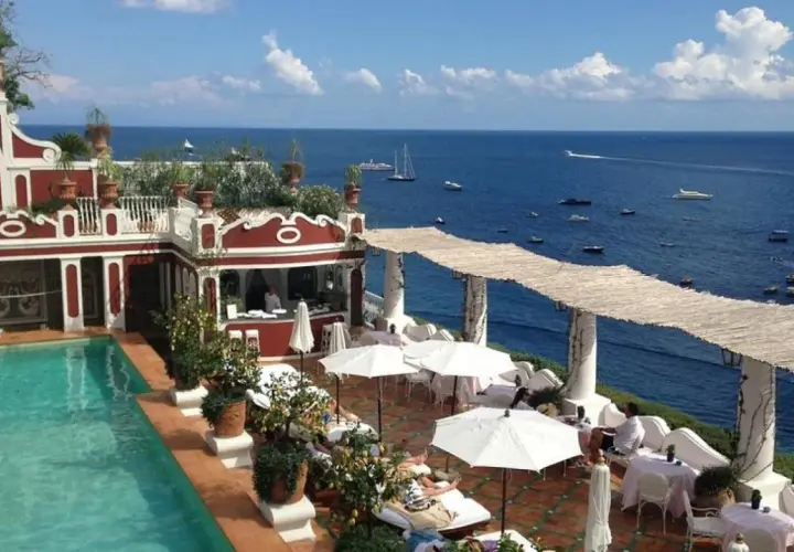 Terraza del Hotel Europa con piscina, tumbonas y vistas al mar azul con barcos.