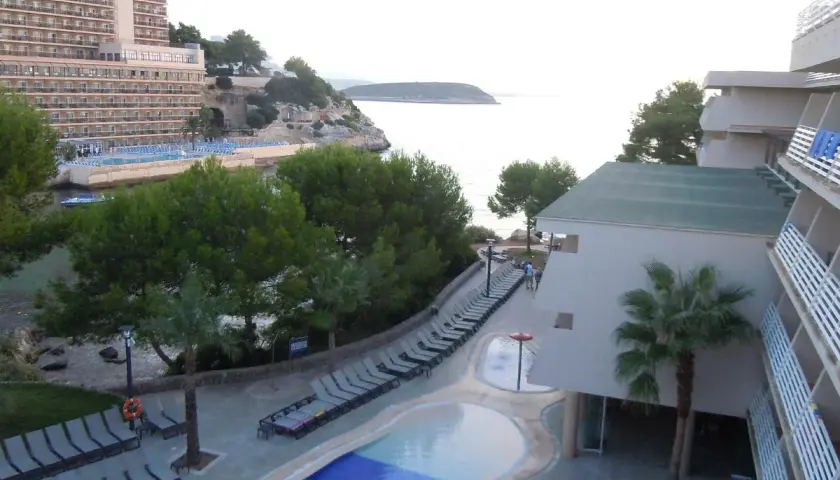 Resort con piscina y tumbonas junto al mar, con vistas a la costa de occidental cala viñas.