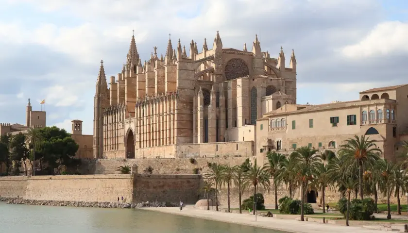 La Catedral de Mallorca, un impresionante edificio gótico, se alza majestuosa junto al mar, evocando la grandeza de Barcelona.