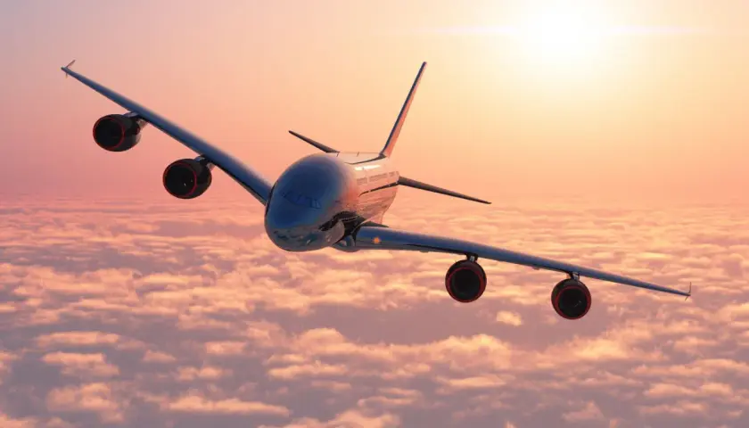 Avión sobrevolando nubes al amanecer, ideal para tus viajes organizados desde Barcelona.