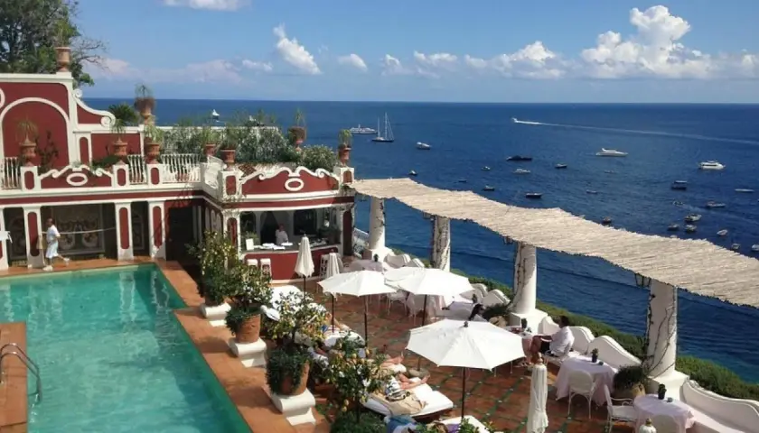 Terraza del Hotel Europa con piscina, tumbonas y vistas al mar azul con barcos.