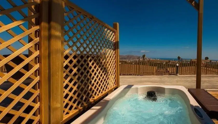 Jacuzzi burbujeante en un balcón con vistas al mar, parte de la experiencia mágica en Natura Resort.