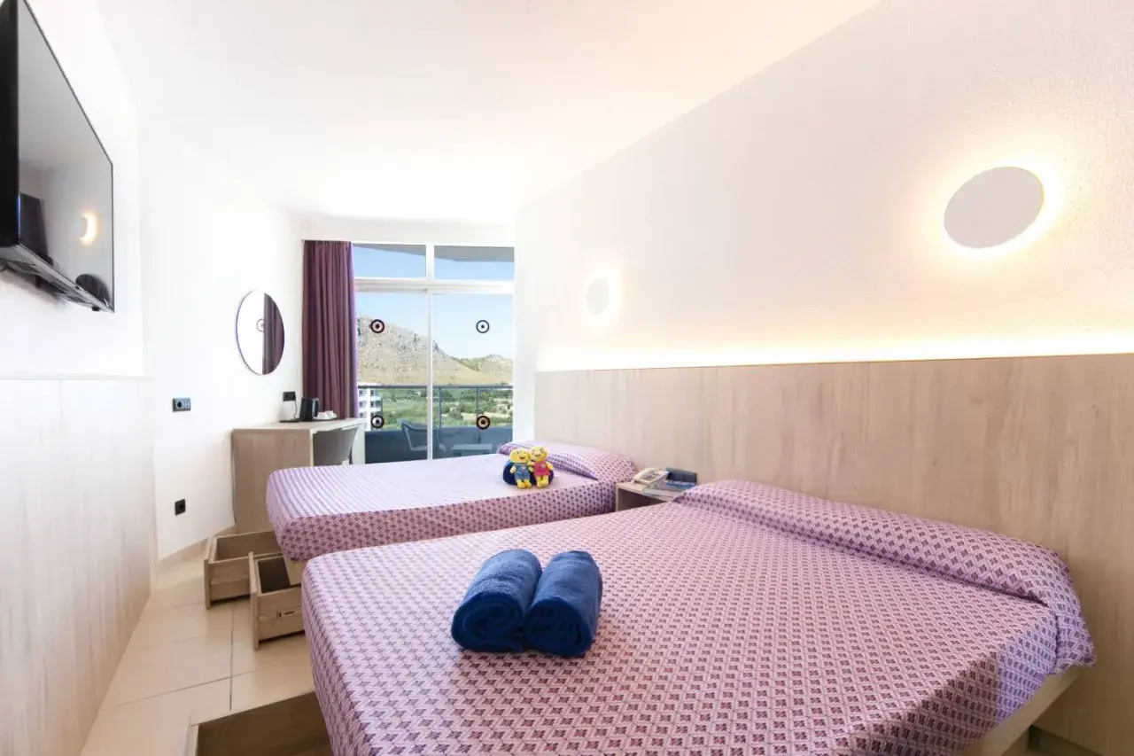 Habitación doble con vistas en Club Mac Alcudia. Dos camas listas para descansar tras un día de sol.