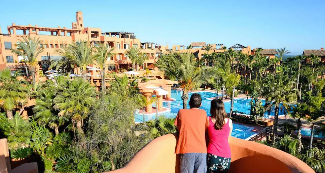 Pareja admira las piscinas y palmeras del Royal Hideaway Sancti Petri.