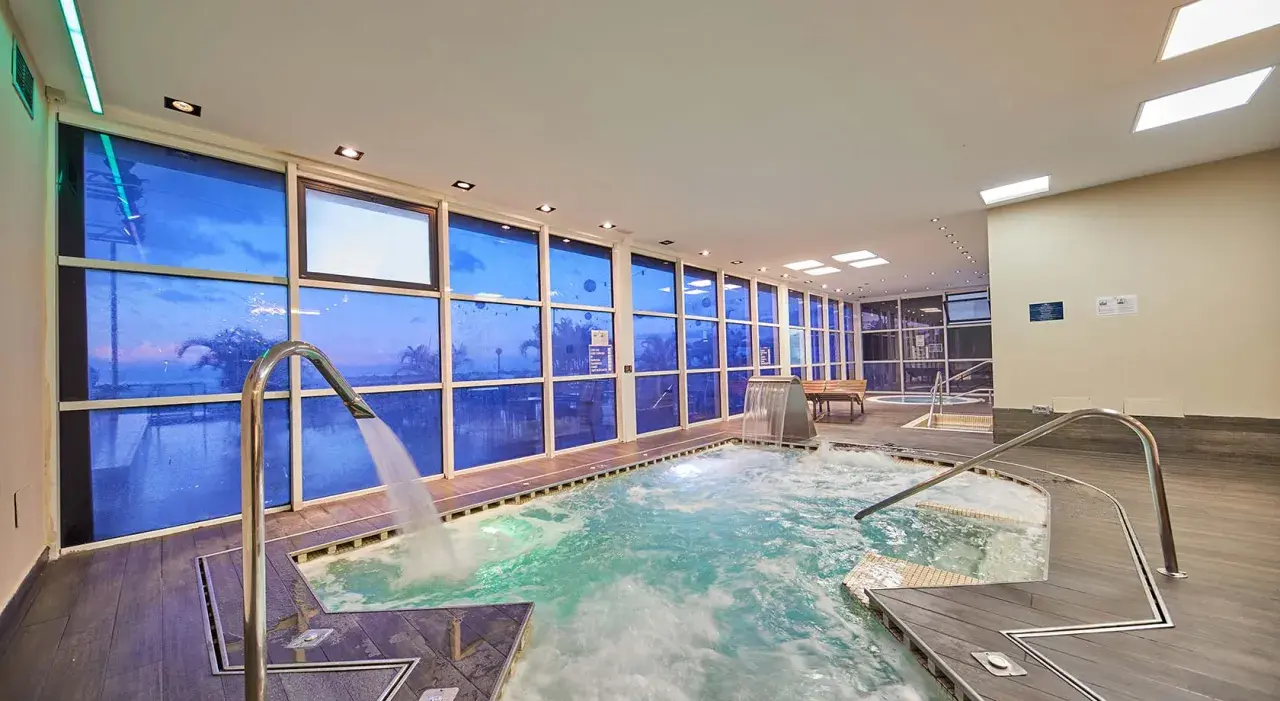 Piscina interior con ventanas azules que reflejan el cielo, cascadas y chorros de agua. Un lugar perfecto para relajarse, como si estuvieras en un spa de tui blue los gigantes.