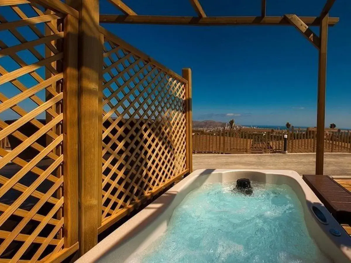 Jacuzzi burbujeante en un balcón con vistas al mar, parte de la experiencia mágica en Natura Resort.
