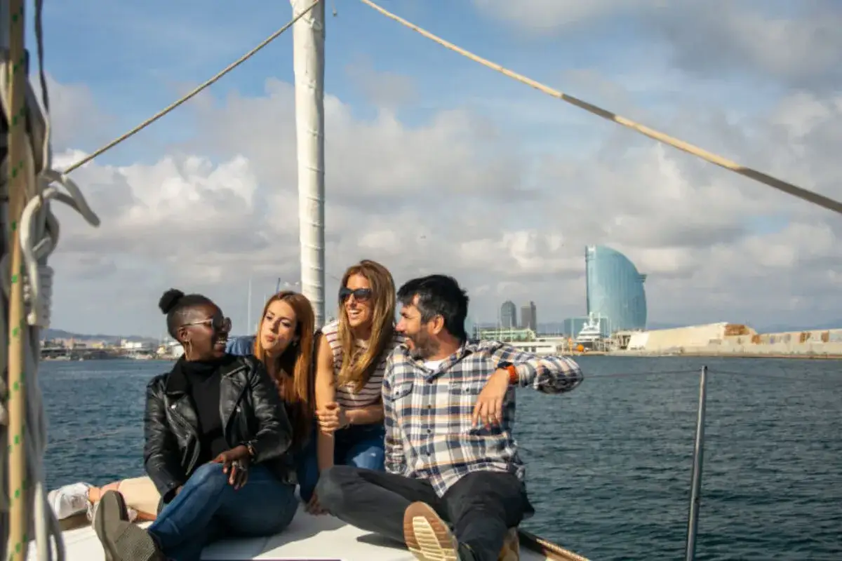 Amigos disfrutan de un paseo en velero, una experiencia ideal para viajes organizados desde Barcelona.